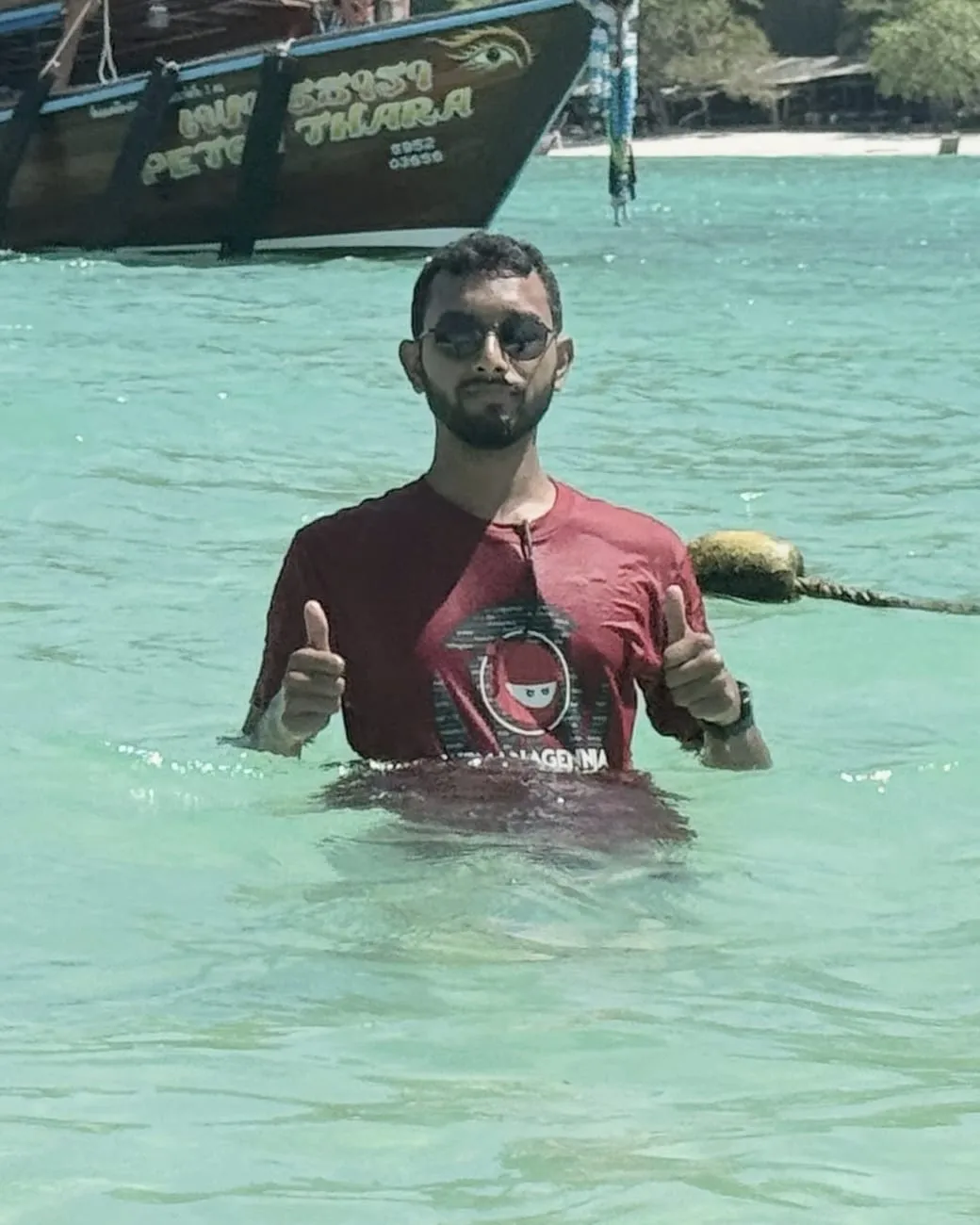 Masiur Rahman Siddiki standing waist-deep in the sea, giving two thumbs up